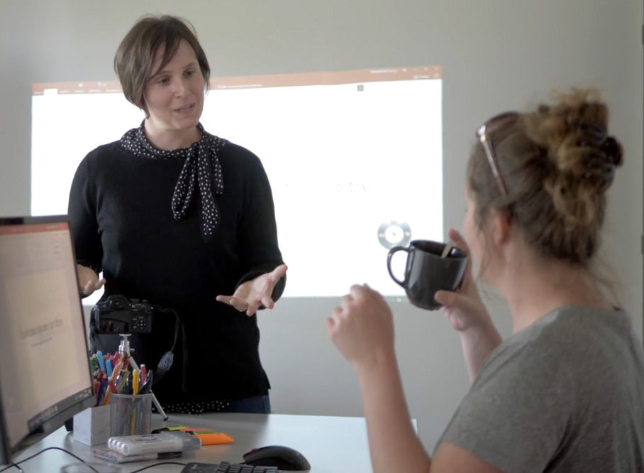 Caroline Dauvergne animant un atelier de formation en soft skills devant un écran avec des participants en entreprise